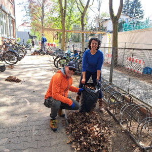 Eltern fleißig am Laubfegen