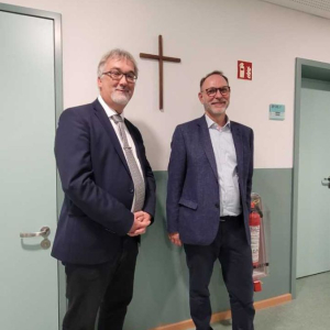 Die Schulleiter Herr Malz und Herr Pritsch vor dem geweihten Kreuz